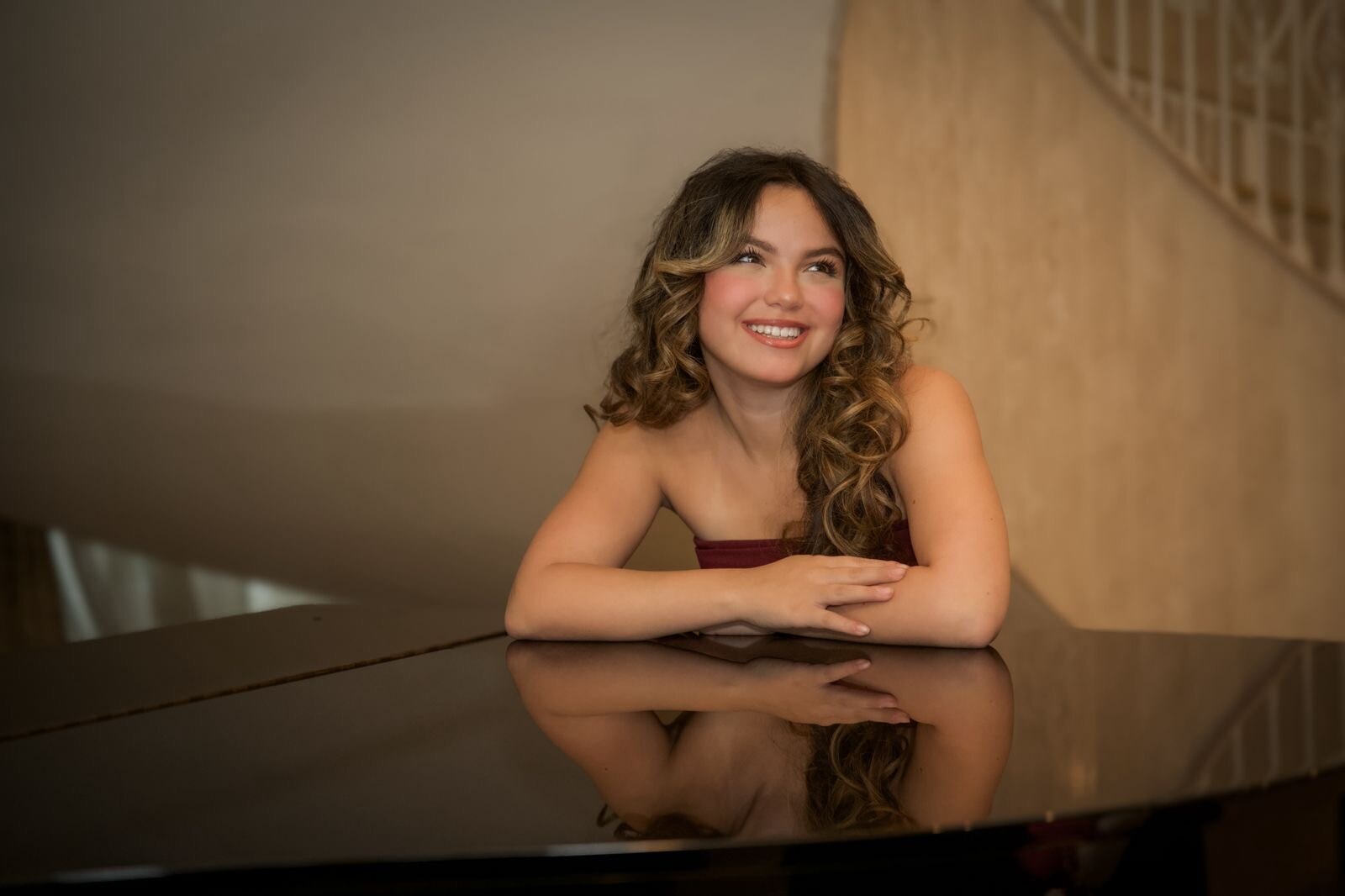 Young woman reflected in a grand piano during an editorial portrait session