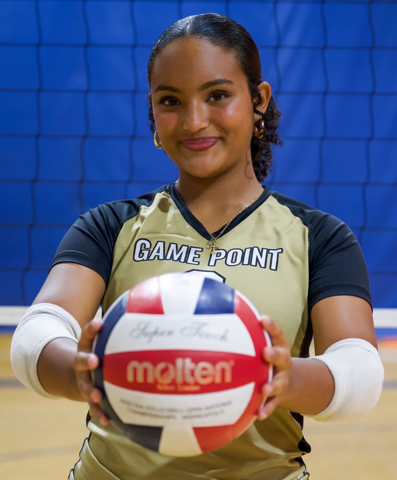 Volleyball athlete holding a ball on the court
